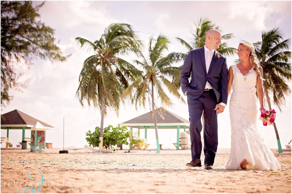groom in navy on beach with bride