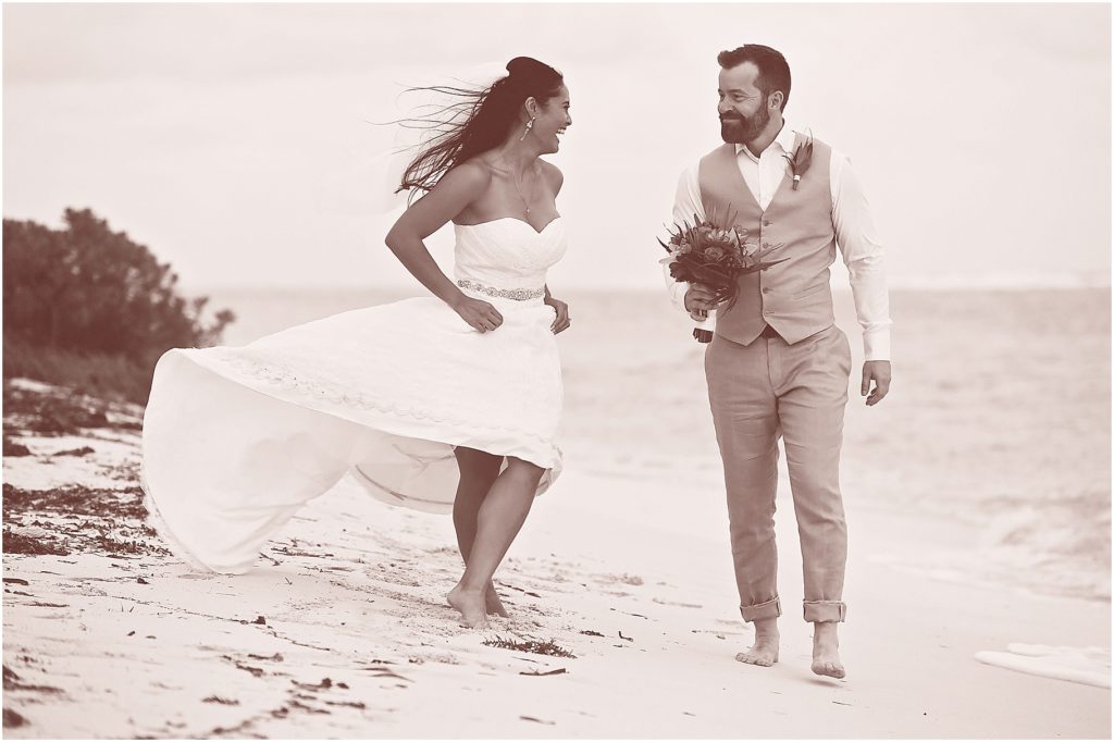 black and white of couple walking down beach