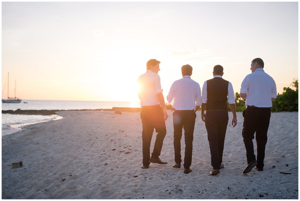 groomsmen walking on wharf beach