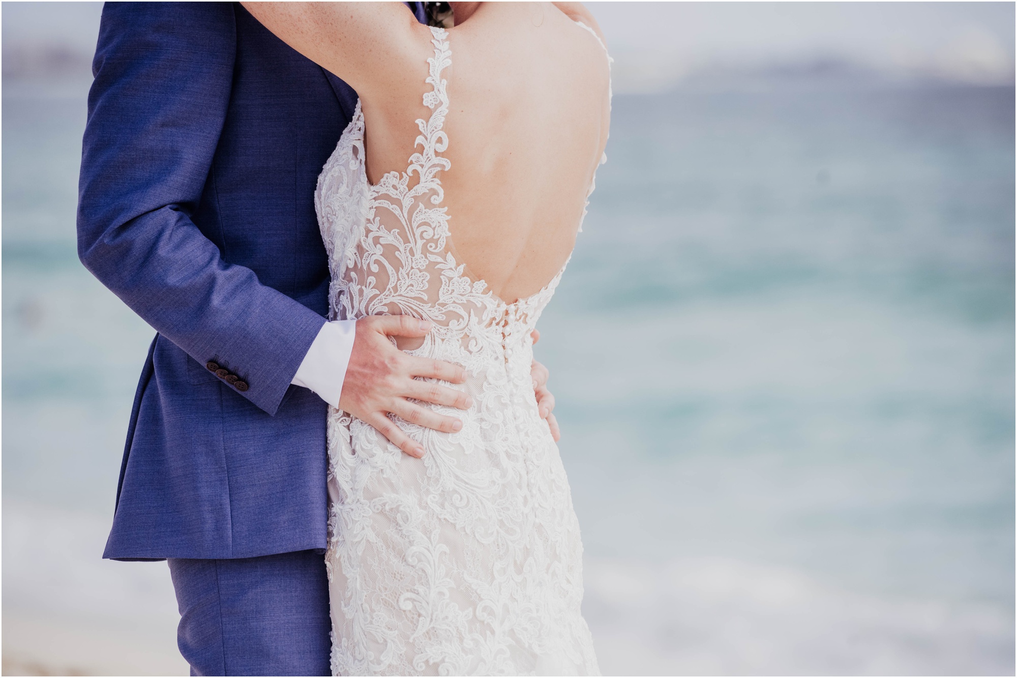 groom in navy blue suit bride in essence of austria on beach