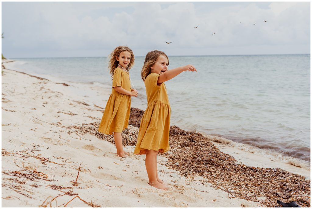 little girls on beach with yellow dresses boho family beach session